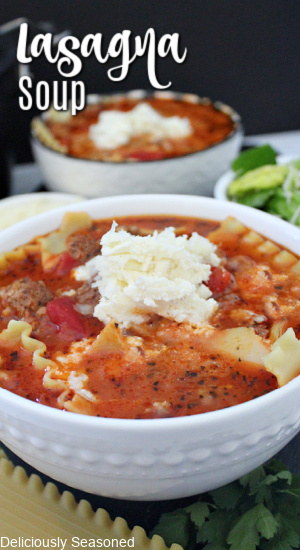 A white bowl of lasagna soup with anther bowl in the background filled with soup.