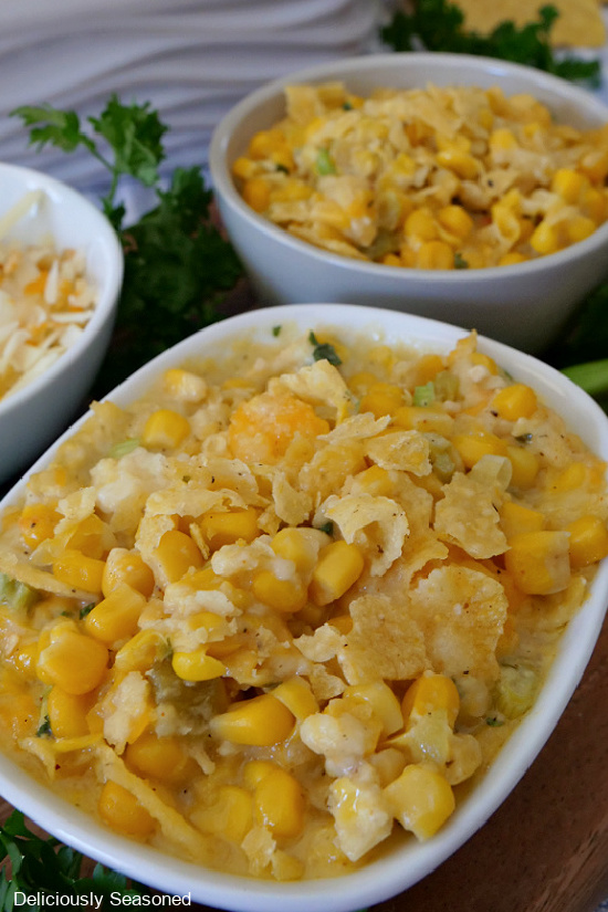 A close up photo of a white bowl with green chili corn casserole in it.