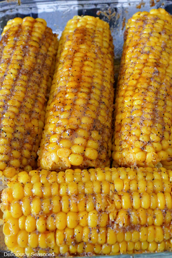 4 ears of Cajun Buttered corn on the cob in a glass baking dish.