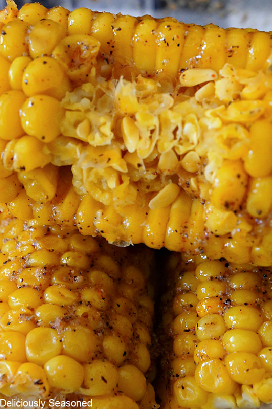 A super close up photo of a bite taken out of an ear of Cajun Buttered corn on the cob.