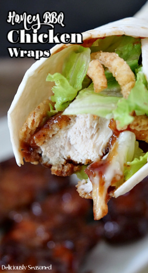 Honey BBQ chicken wrap in a flour tortilla with lettuce, ranch dressing, and fried onions.