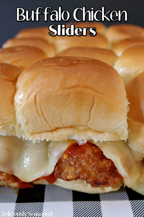 An extremely close up photo of a single buffalo chicken slider on a black and white checkered placemat.