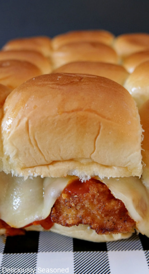 A close up view of a buffalo chicken slider sitting on a black and white checkered placemat.