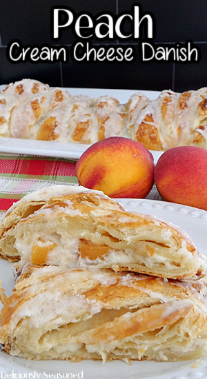 Peach Cream Cheese Danish slices on a white plate with two peaches and a whole danish in the background, and the title of the recipe at the top of the photo.