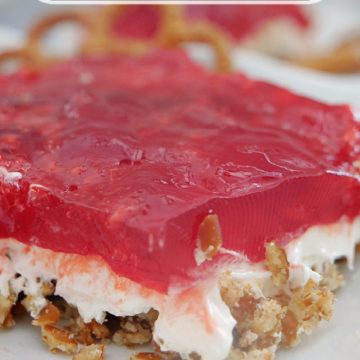 A square slice of Raspberry Pretzel Salad on a white plate with the title of the recipe at the top of the photo.