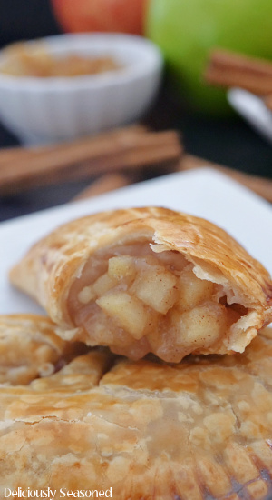 A close up photo of apple cinnamon hand pies on a small white plate.