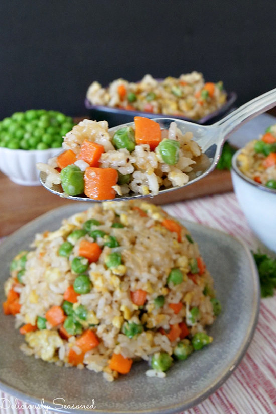 Fried Rice in smalls bowls with a spoonful of rice, peas, carrots, and scrambled eggs.