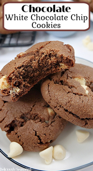 Chocolate cookies with white chocolate chips stacked up on a white plate.