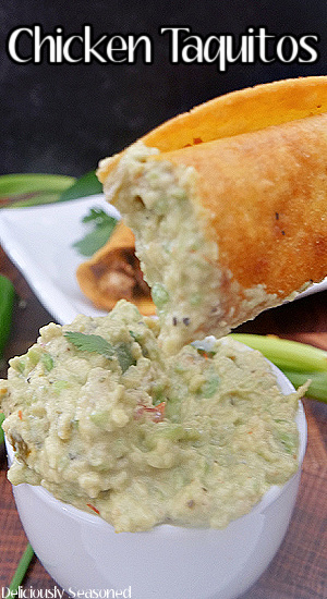 A chicken taquito that has been dipped in guacamole.