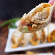 A half eaten baked chicken taco showing the inside ingredients.