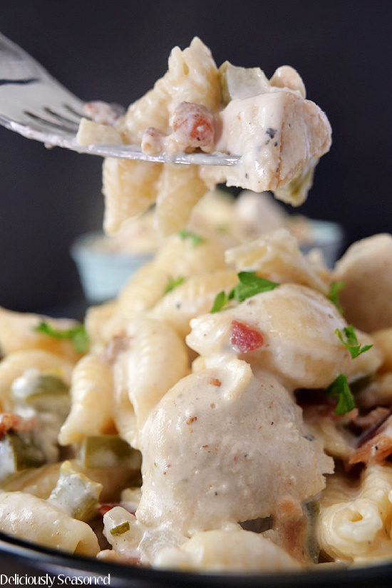 A close up photo of a forkful of chicken bacon ranch pasta.
