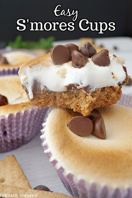 Two s'mores cups stacked up on top of each other, filled with marshmallow fluff and topped with chocolate chips.