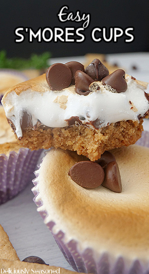 Two smores cups stacked on top of one another, topped with chocolate chips and marshmallow fluff.