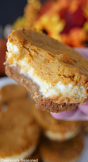 A close up photo of a mini pumpkin cheesecake with a bite taken out of it.