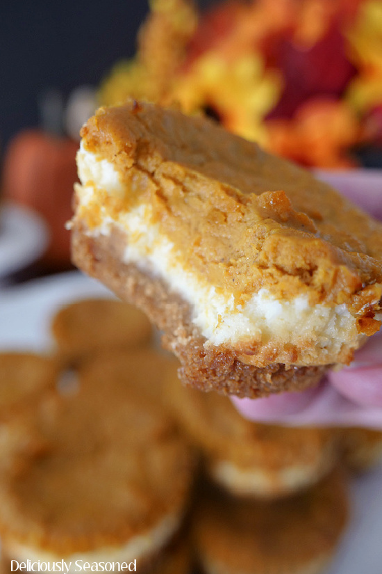 A close up photo of a mini pumpkin cheesecake with a bite taken out of it.