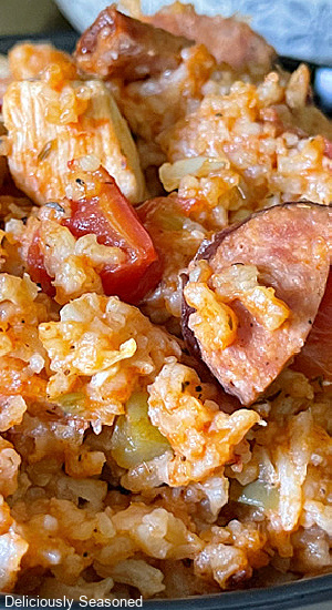 A close up photo of jambalaya with diced chicken and sliced andouille sausage. 