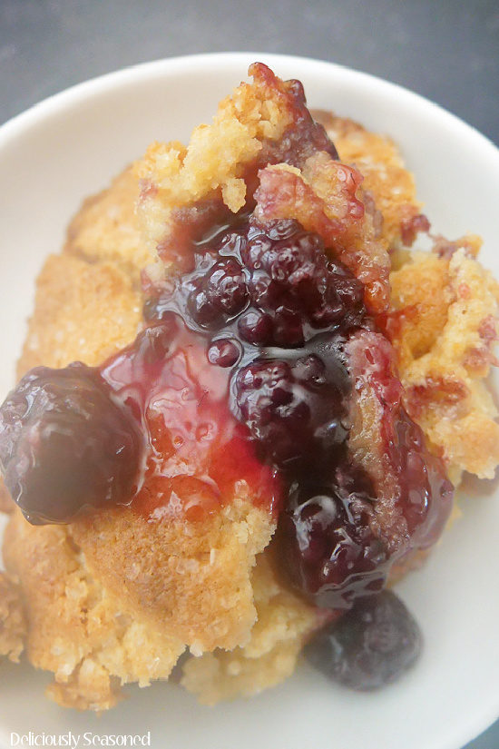 A close up of blackberry cobbler in a white bowl.