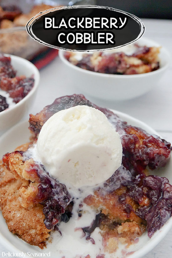 Three white bowls with easy blackberry cobbler in them and a scoop of vanilla ice cream on top. 