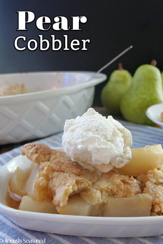 A shallow white bowl filled with pear cobbler with a scoop of vanilla ice cream on top.