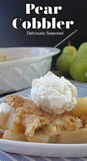 A shallow white bowl with a serving of easy pear cobbler with a scoop of vanilla ice cream on it.