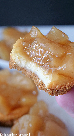A close up of a mini apple cheesecake with a bite taken out of it.