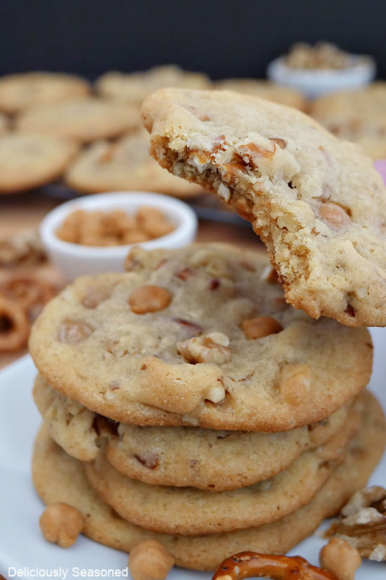 A close up photo of a stack of caramel pretzel cookies with a cookie that has a bite taken out of it.