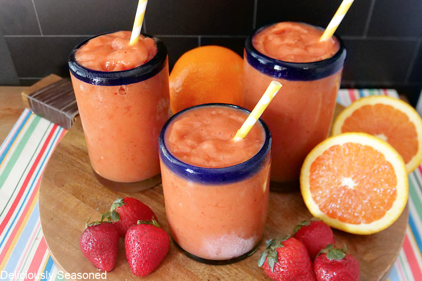 Strawberry Peach Smoothies with strawberries and oranges surrounding the glasses.