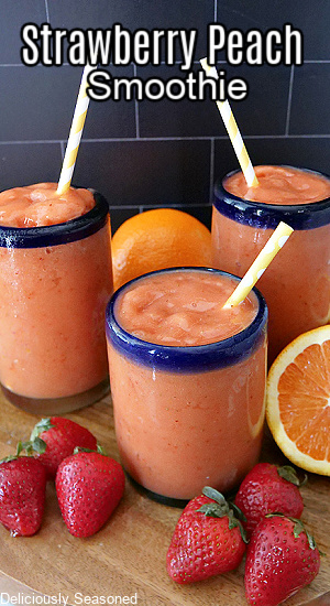 Strawberry Peach Smoothies with strawberries and oranges in the foreground and background.
