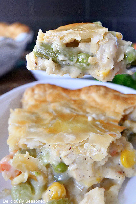 A slice of Turkey Pot Pie on a plate with a bite of pie on a fork.