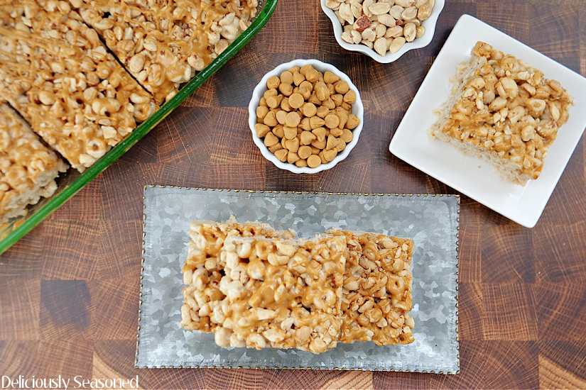 An overhead picture of Honey Nut Cheerio Marshmallow Treats stacked up on a plate and in a glass dish with a bowl of butterscotch chips in the middle.