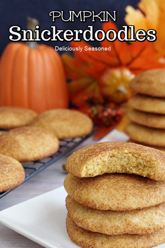 Pumpkin snickerdoodle cookies on a white plate and some on a wire rack in the background.
