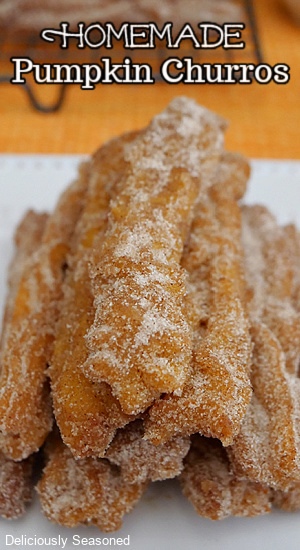 A close up photo of pumpkin churros stacked up, coated in cinnamon and sugar.