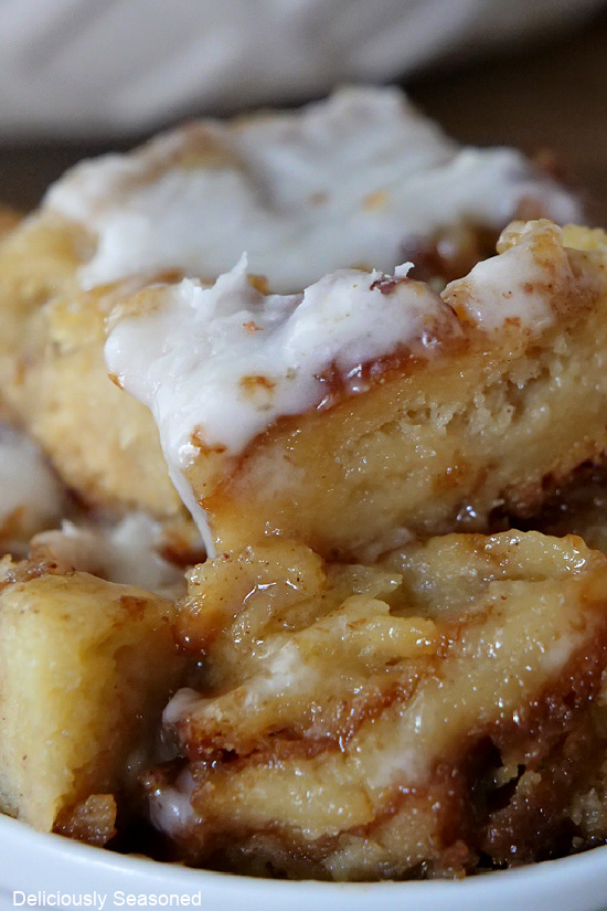 A close up picture of butter pecan bread pudding with glaze on top and melted down the sides.