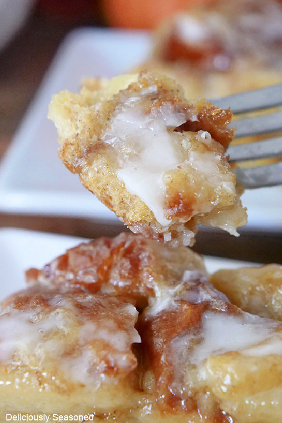 A close up photo of a bite of bread pudding on a fork.