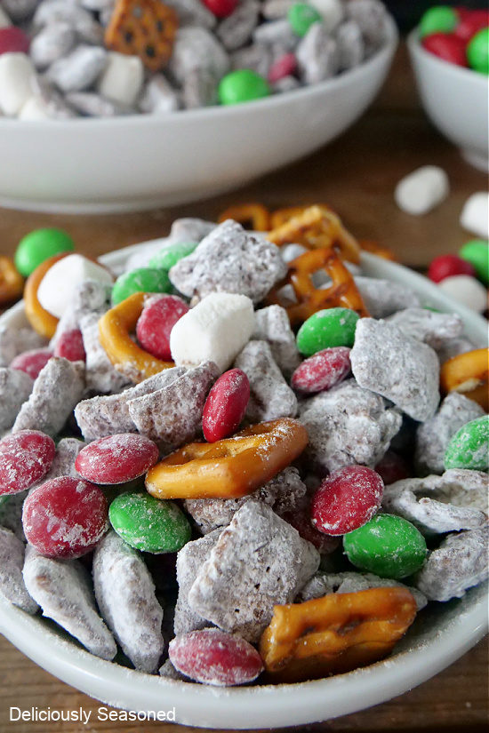 A white bowl filled with Christmas muddy buddy Chex mix.