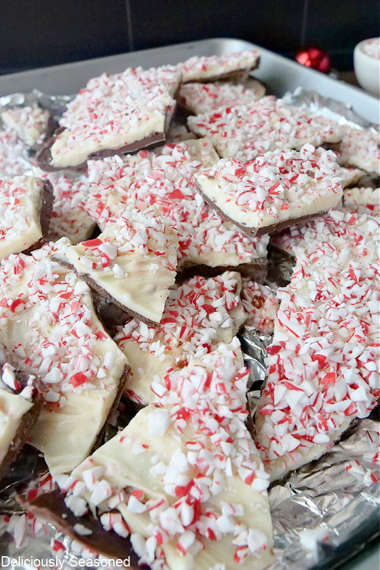 Peppermint bark pieces stacked on a baking sheet.