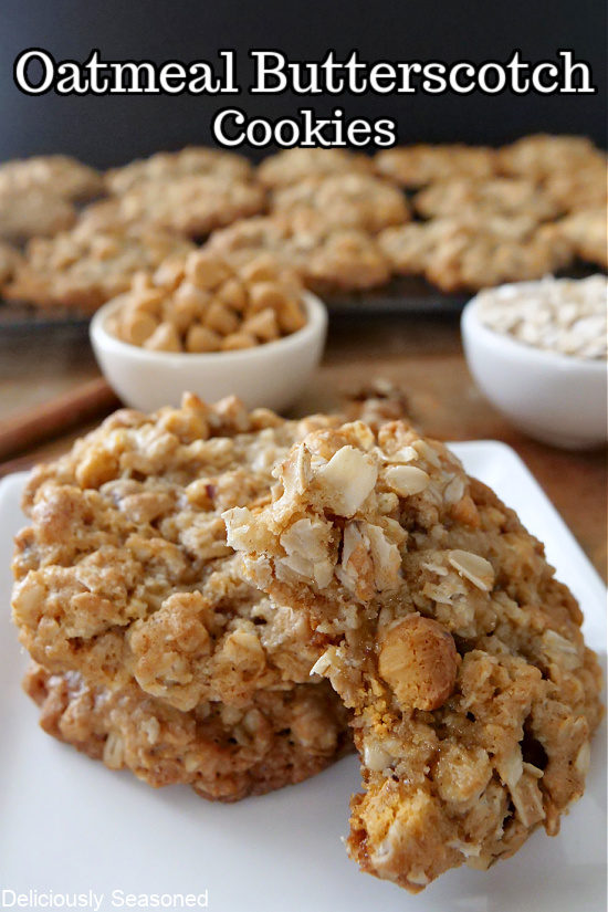 A close up of 3 oatmeal cookies with butterscotch morsels on a white plate.