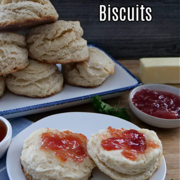 Two biscuit halves on a white plate with jelly on them.
