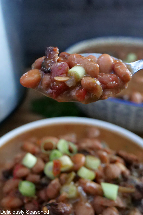A close up of a spoonful of charro beans.