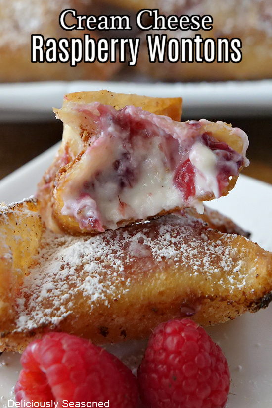 A wontons filled with cream cheese and raspberry filling and sprinkled with powdered sugar.