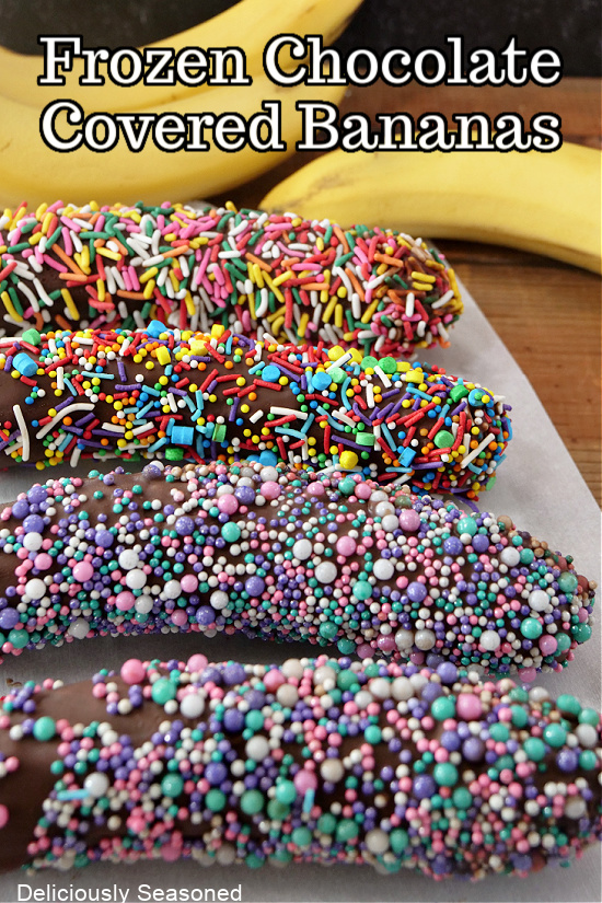 Four chocolate covered bananas coated in colorful sprinkles and laying on a white plate.