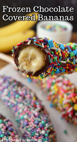 A chocolate covered banana with a bite taken out of it.