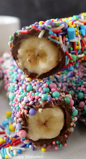 Two bananas covered in chocolate and sprinkles, with a bite taken out of each banana.