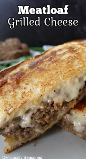 A close up pic of a meatloaf grilled cheese cut in half.