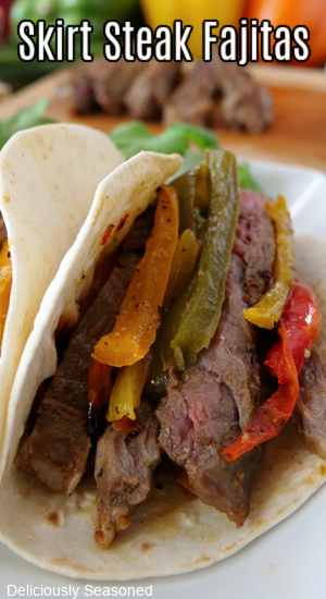 Steak fajitas with four different colored bell peppers, onions, in a flour tortilla.