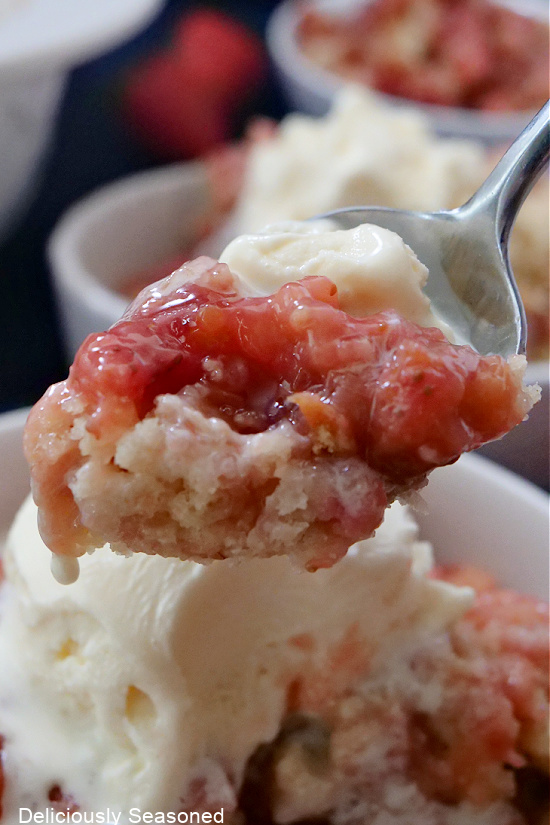 A bite of cobbler and vanilla ice cream on a spoon.