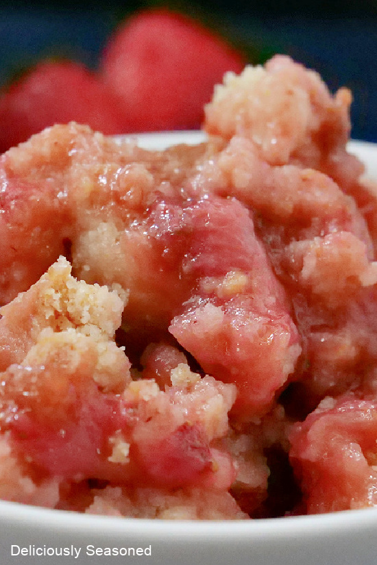 A close up photo of strawberry rhubarb cobbler in a white bowl.