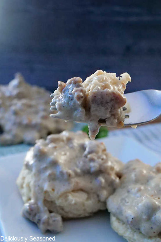 A bite of biscuits and gravy on a fork.