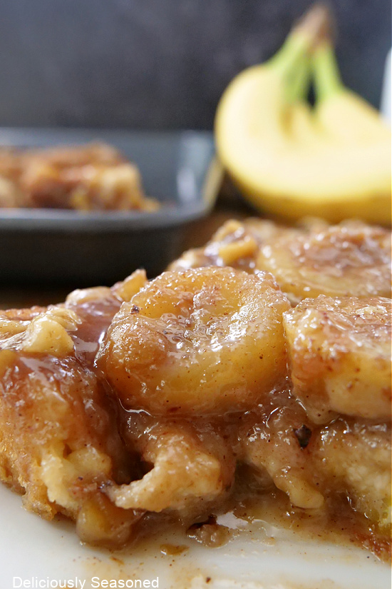 A close up photo of a piece of french toast loaded with bananas and a delicious topping.