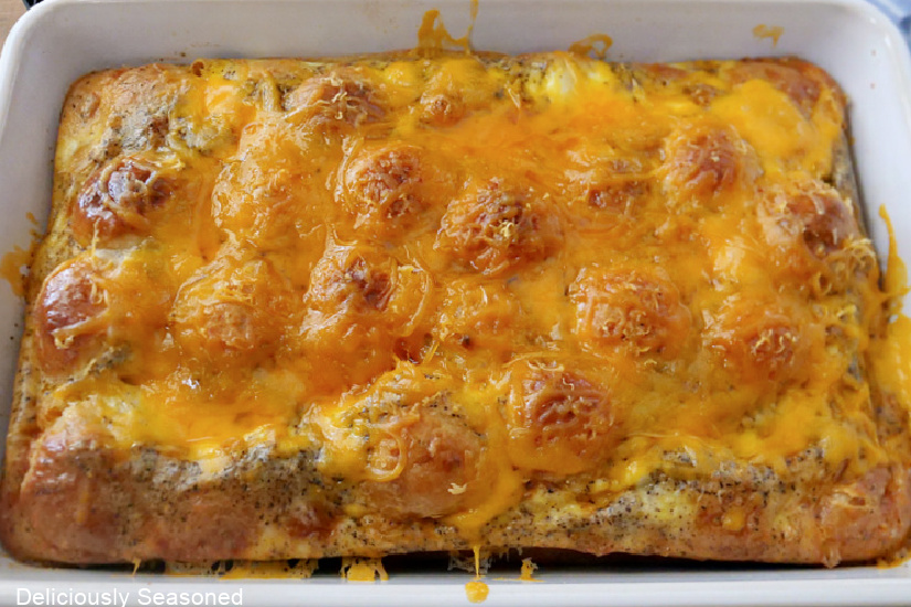 A white baking dish with breakfast biscuit casserole after being pulled from the oven before being served.